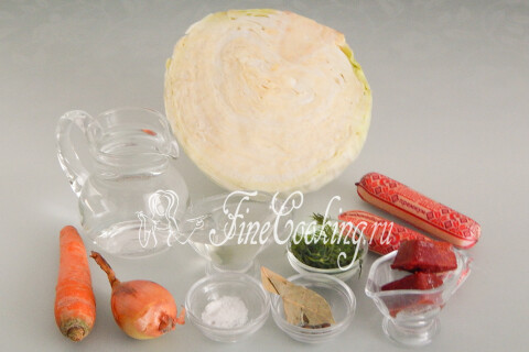 Продукты для тушёной капусты с сосисками: капуста, сосиски, морковь, лук, томатная паста, лавровый лист, перец и укроп.