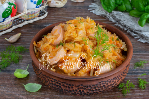 Тушёная капуста с сосисками, посыпанная измельчённым укропом, в тарелке.