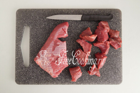 Говядина, нарезанная небольшими кусочками, на разделочной доске