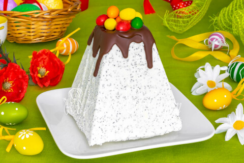 Разрезанный десерт показывает слои с маком и шоколадной серединкой.