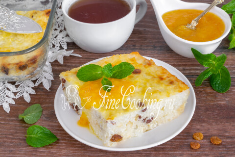 Готовая творожная запеканка с рисом и изюмом на столе с вареньем.