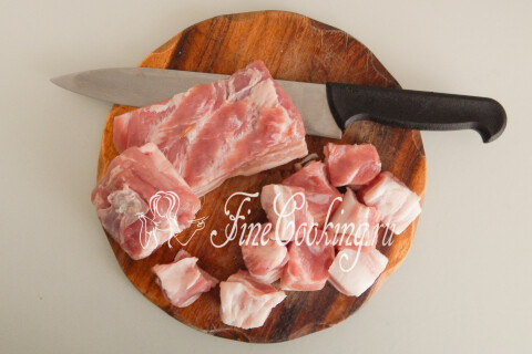 Свинина, нарезанная крупными кусками, на разделочной доске