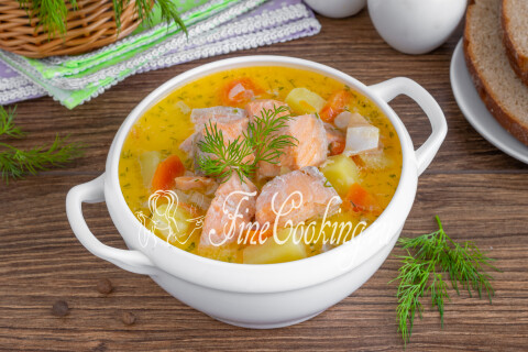 Тарелка финской ухи со сливками, поданная с хлебом и укропом