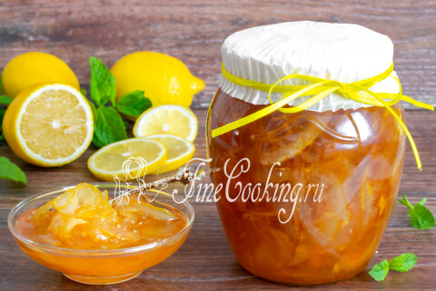Лимонное варенье в розетке рядом с чашкой чая и блинами.