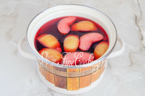 Компот из вишни с яблоками в кастрюле, настоявшийся под крышкой