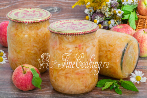 Открытая банка яблочной начинки с ложкой на столе