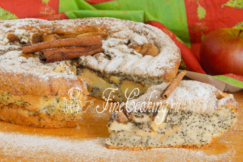 Кусок яблочной шарлотки с маком на тарелке рядом с чаем