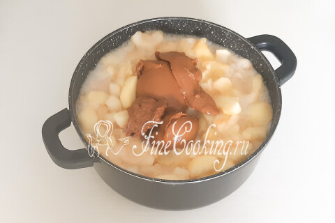 Кастрюля с мягкими яблоками, соком и куском варёной сгущёнки.