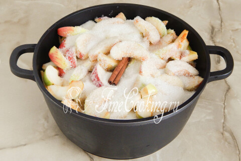 Кастрюля с яблоками, сахаром и палочкой корицы, накрытая крышкой