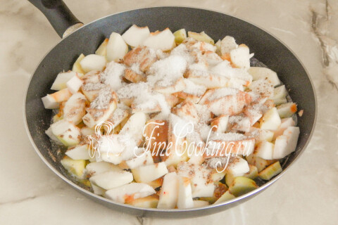 Яблоки в сковороде, посыпанные сахаром, корицей и политые лимонным соком