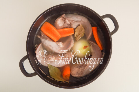 Очищенные морковь и лук рядом с кастрюлей с языками