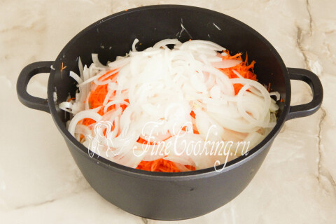 Репчатый лук, нарезанный тонкими полукольцами, на разделочной доске