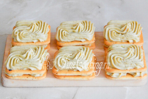 Украшенные муссом крекеры уложены поверх нижнего слоя закуски