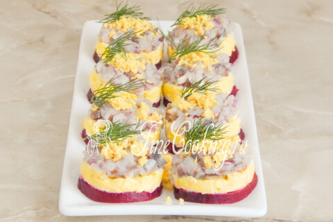 Каждая порция закуски украшена тёртым желтком и веточкой укропа.