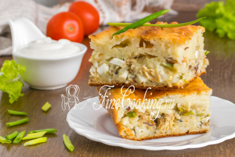 Заливной пирог с рыбными консервами и рисом на тарелке в разрезе.