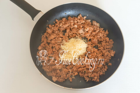 Готовый мясной фарш с тёртым сыром, перемешанный в сковороде.