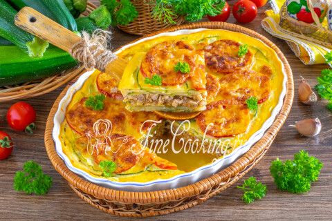 Готовая запеканка из кабачков, фарша, помидоров и сыра, нарезанная порциями.