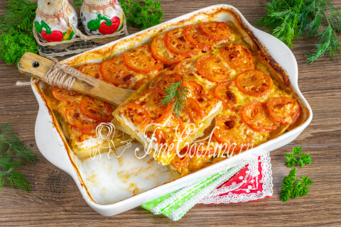 Запеканка из картофеля с курицей, помидорами и сыром на тарелке.