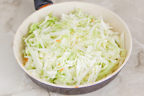 Нашинкованная капуста, тушащаяся с овощами под крышкой
