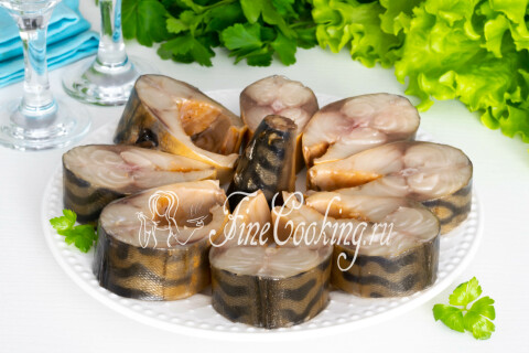 Скумбрия нарезана порционными кусочками и подана на тарелке как закуска.