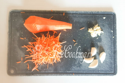 Морковь, натёртая на тёрке для корейской моркови, и пропущенный через пресс чеснок рядом.