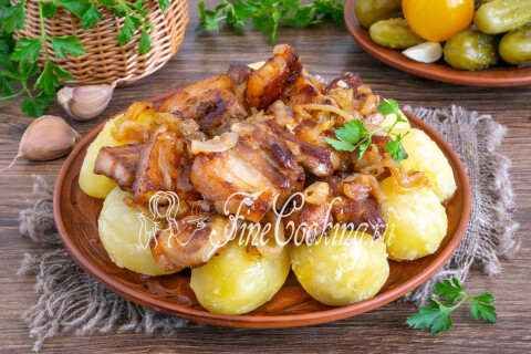 Тарелка с жареной свиной грудинкой, луком, варёной картошкой и солёностями