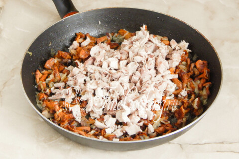 Куриное мясо переложено к грибам с луком и прогревается на сковороде